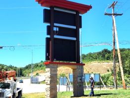 The back side view of the Greater Portsmouth Regional Airport sign showing the routing of electrical from underground service to power supply boxes behind the signs