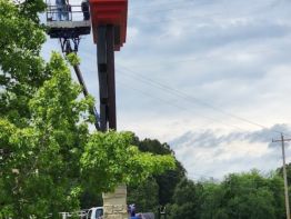 The end view of the Greater Portsmouth Regional Airport sign showing the beautiful stone details on the columns and the banking of the jet above the roofline